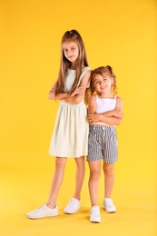 Photo of Full length portrait of cute girls on yellow background