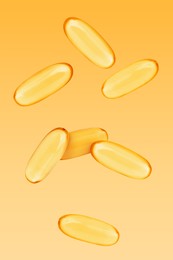 Image of Vitamin. Softgel capsules falling on orange gradient background