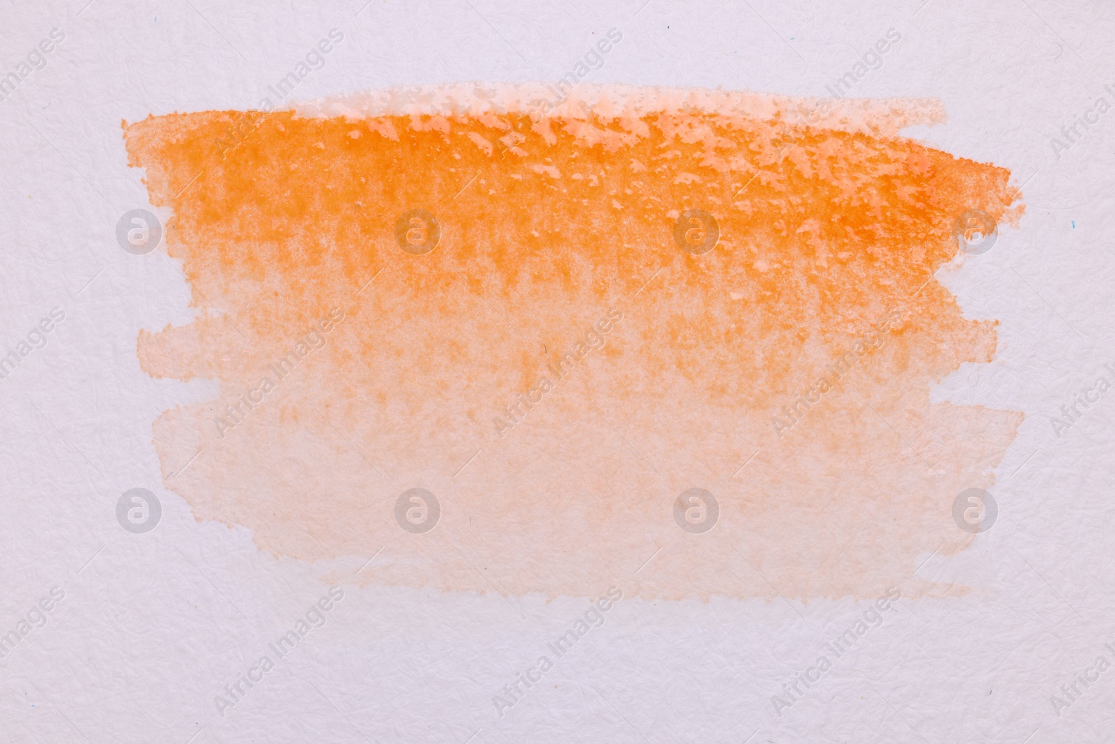 Photo of Abstract orange watercolor painting on white paper, top view