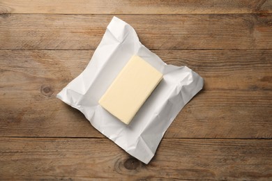 Photo of Block of tasty butter on wooden table, top view