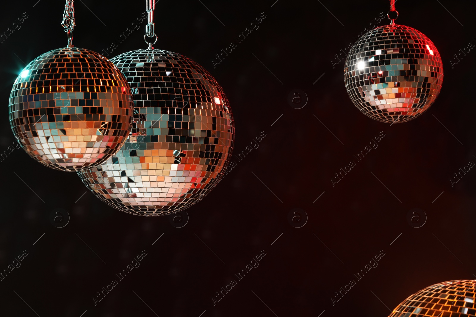 Photo of Shiny bright disco balls on dark background