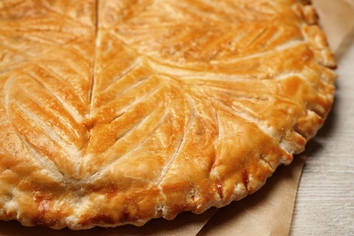 Traditional galette des rois on white wooden table, closeup