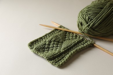 Photo of Knitting, soft yarn and needles on beige background