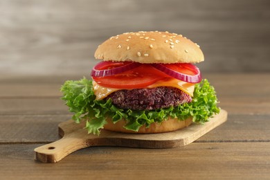 Photo of Tasty vegetarian burger with beet patty on wooden table