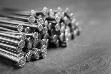 Photo of Many metal nails on grey background, closeup. Space for text