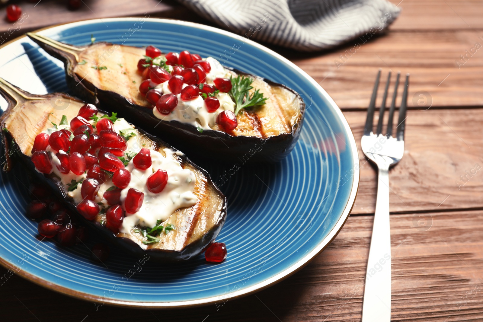 Photo of Plate with fried eggplants on wooden table