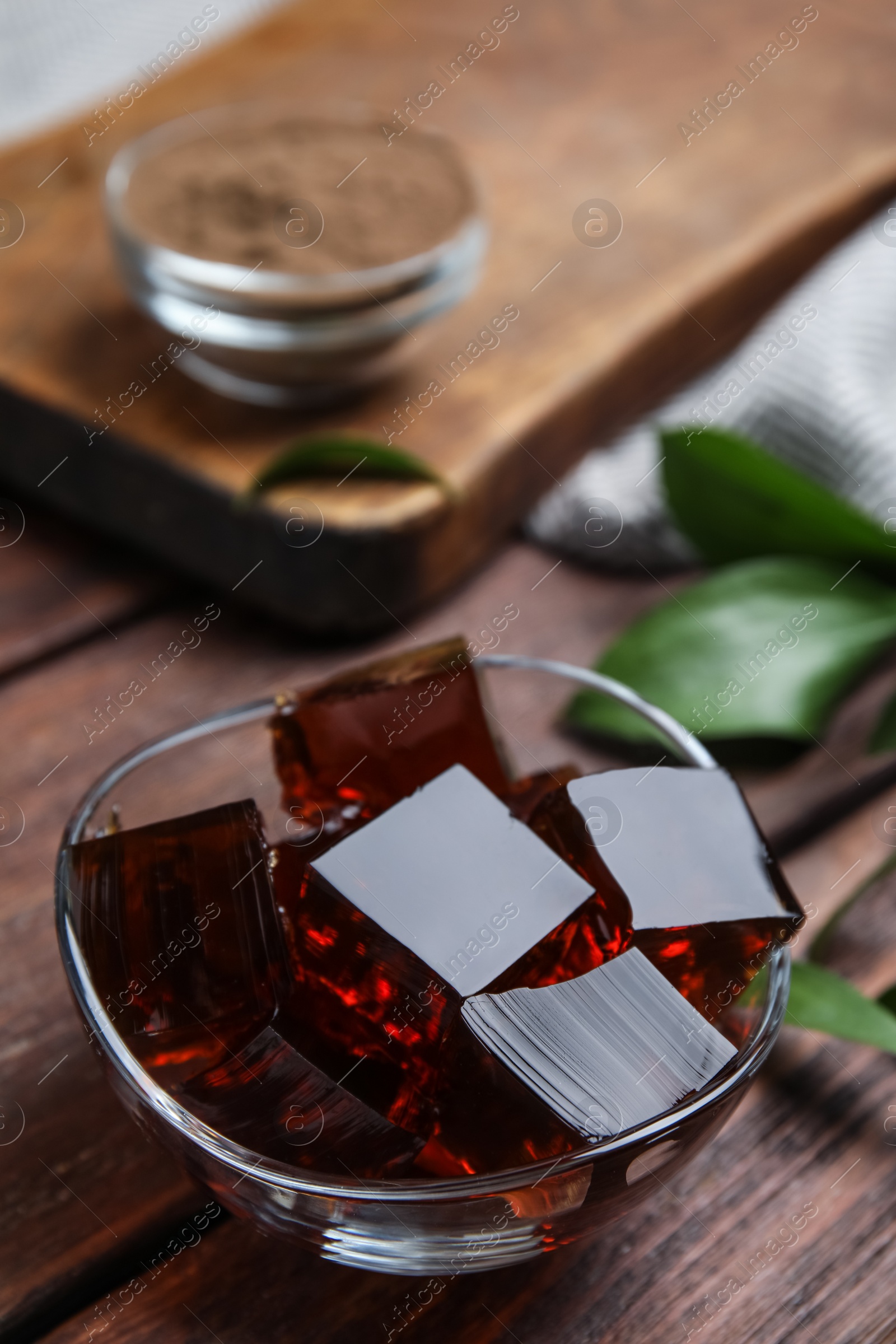 Photo of Delicious grass jelly cubes on wooden table, closeup