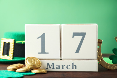 Photo of Composition with block calendar on wooden table. St. Patrick's Day celebration