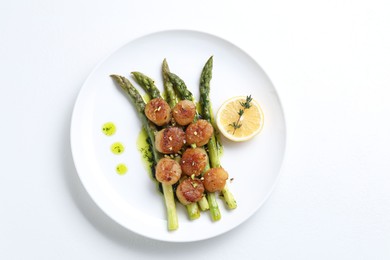 Photo of Delicious fried scallops with asparagus, lemon and thyme on white background, top view