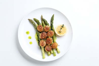 Delicious fried scallops with asparagus, lemon and thyme on white background, top view