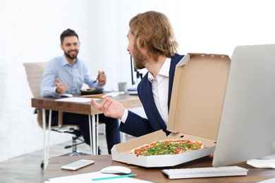 Office employees having lunch at workplace. Food delivery