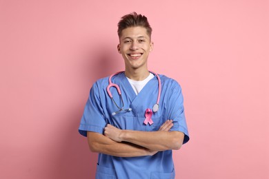 Photo of Mammologist with pink ribbon on color background. Breast cancer awareness