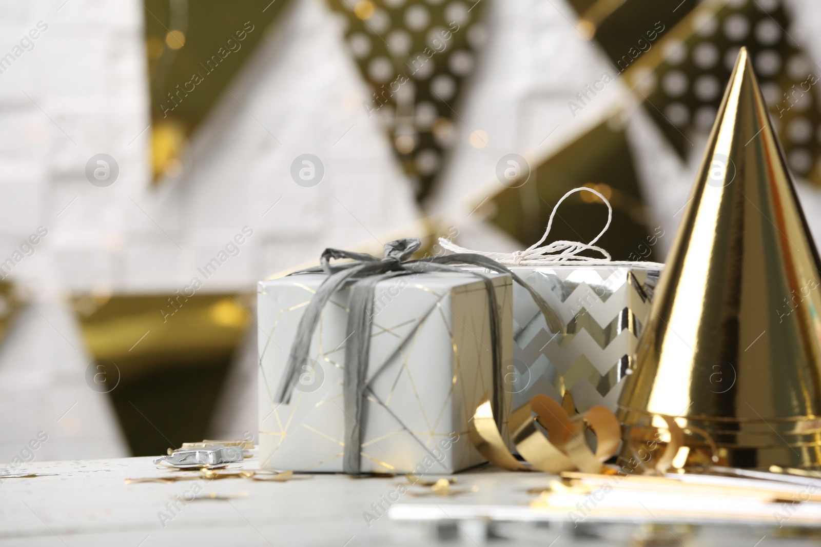 Photo of Gifts and party cones on table against blurred background