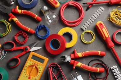 Flat lay composition with electrician's tools and accessories on grey background