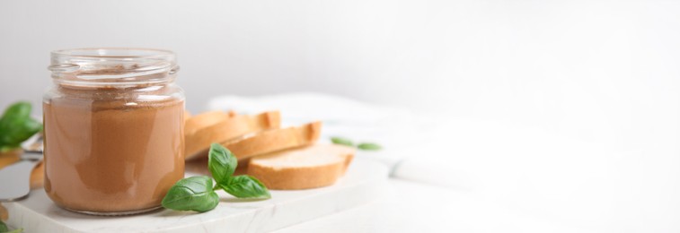 Image of Jar with delicious pate, basil and slices of bread on white table, space for text. Banner design