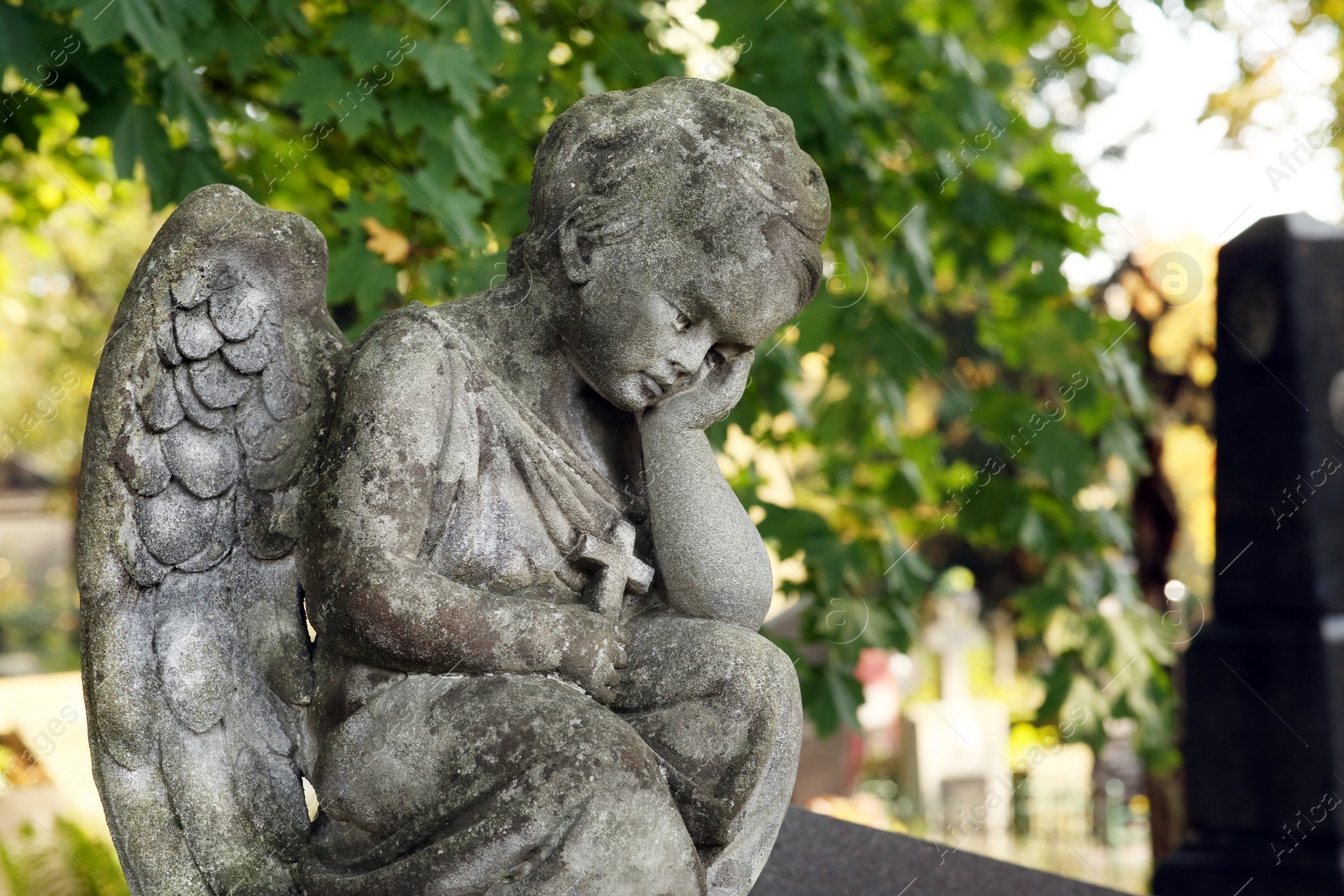 Photo of Beautiful statue of angel at cemetery on sunny day, space for text. Funeral ceremony