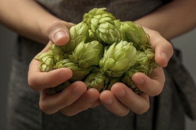 Photo of Woman holding pile of fresh ripe hops, closeup