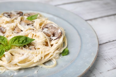 Photo of Delicious pasta with mushrooms and cheese on white wooden table, closeup