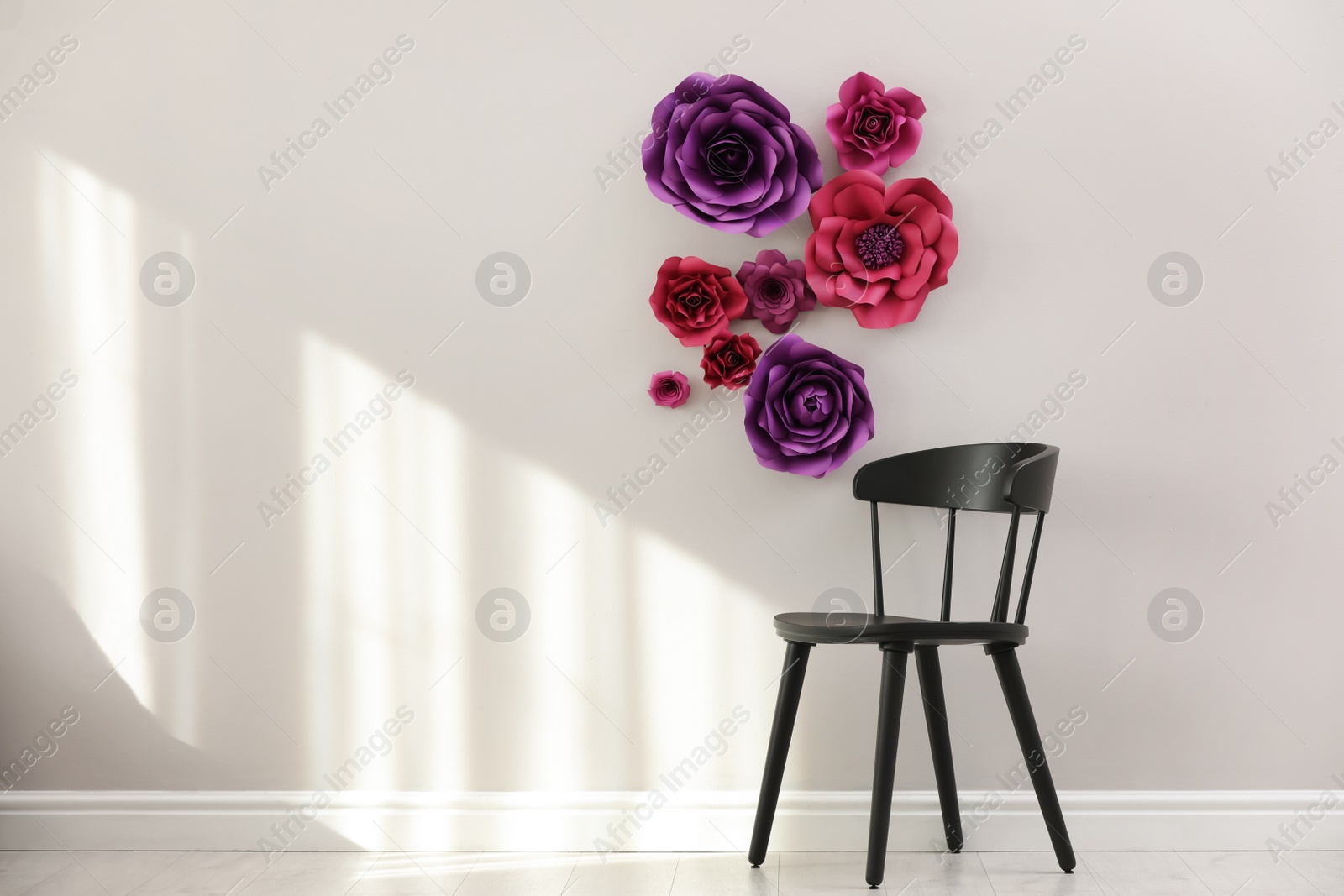 Photo of Stylish room interior with floral decor and black chair, space for text