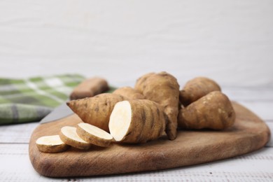 Whole and cut turnip rooted chervil tubers on wooden table