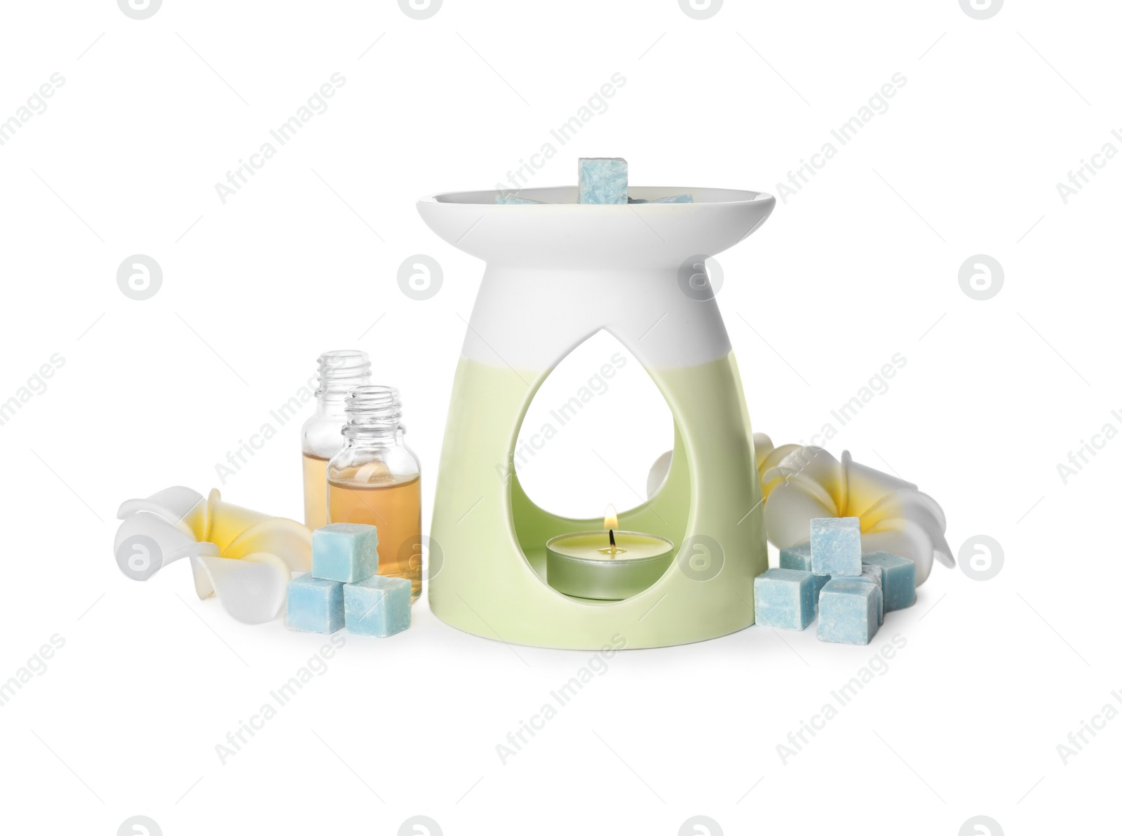 Photo of Stylish aroma lamp with essential wax cubes, oil and flowers on white background