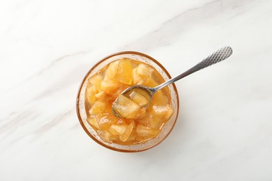 Photo of Delicious apple jam on white table, top view