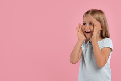 Photo of Special promotion. Little girl shouting to announce information on pink background. Space for text