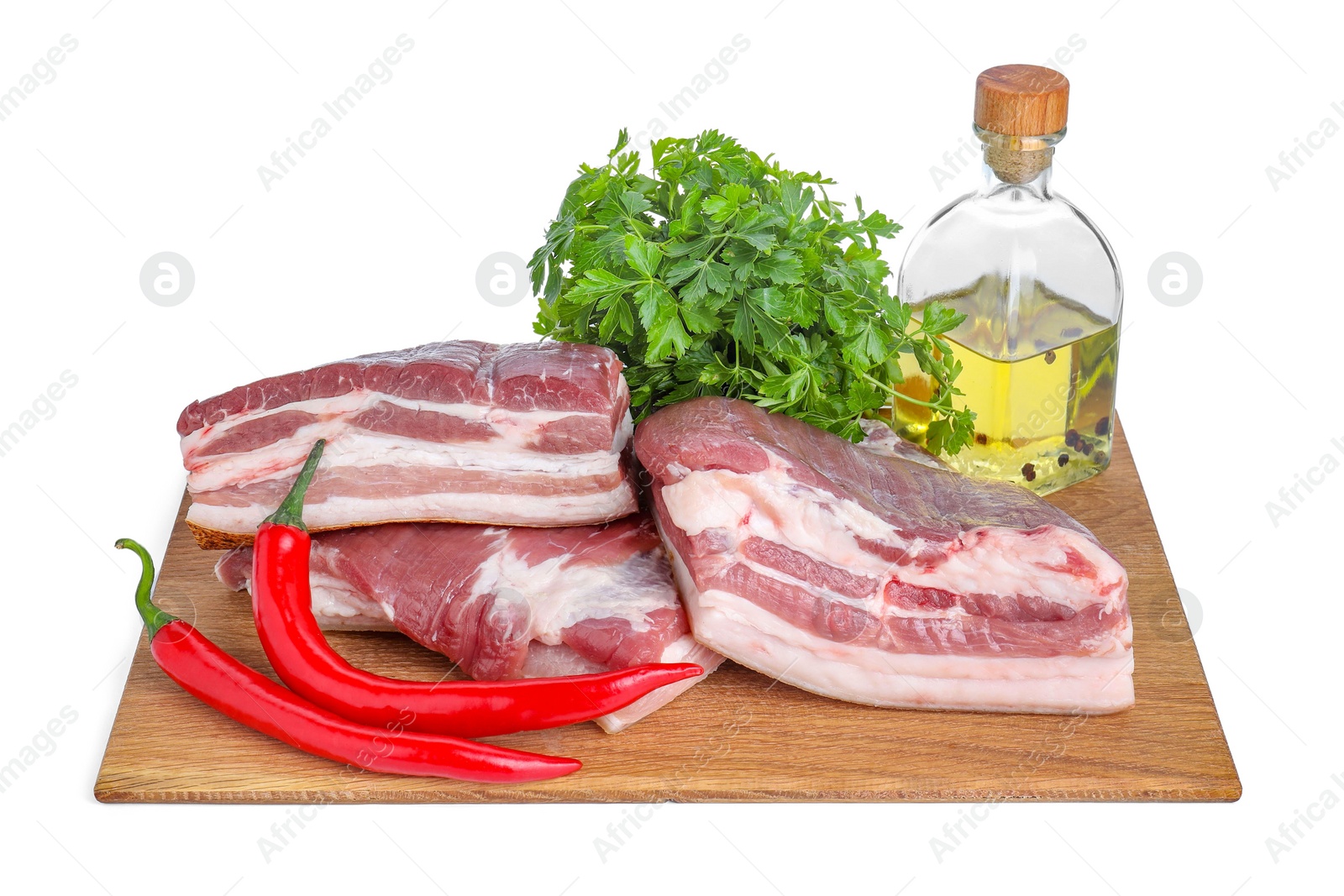 Photo of Pieces of raw pork belly, parsley, chili peppers and oil isolated on white