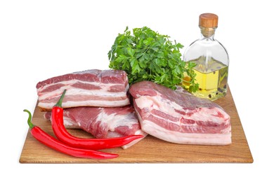 Pieces of raw pork belly, parsley, chili peppers and oil isolated on white