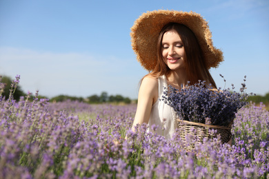 Photo of Young woman with wicker basket full of lavender flowers in field