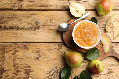 Photo of Delicious pear jam and fresh fruits on wooden table, flat lay. Space for text