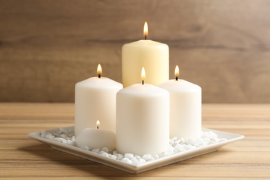 Photo of Composition with burning candles on wooden table