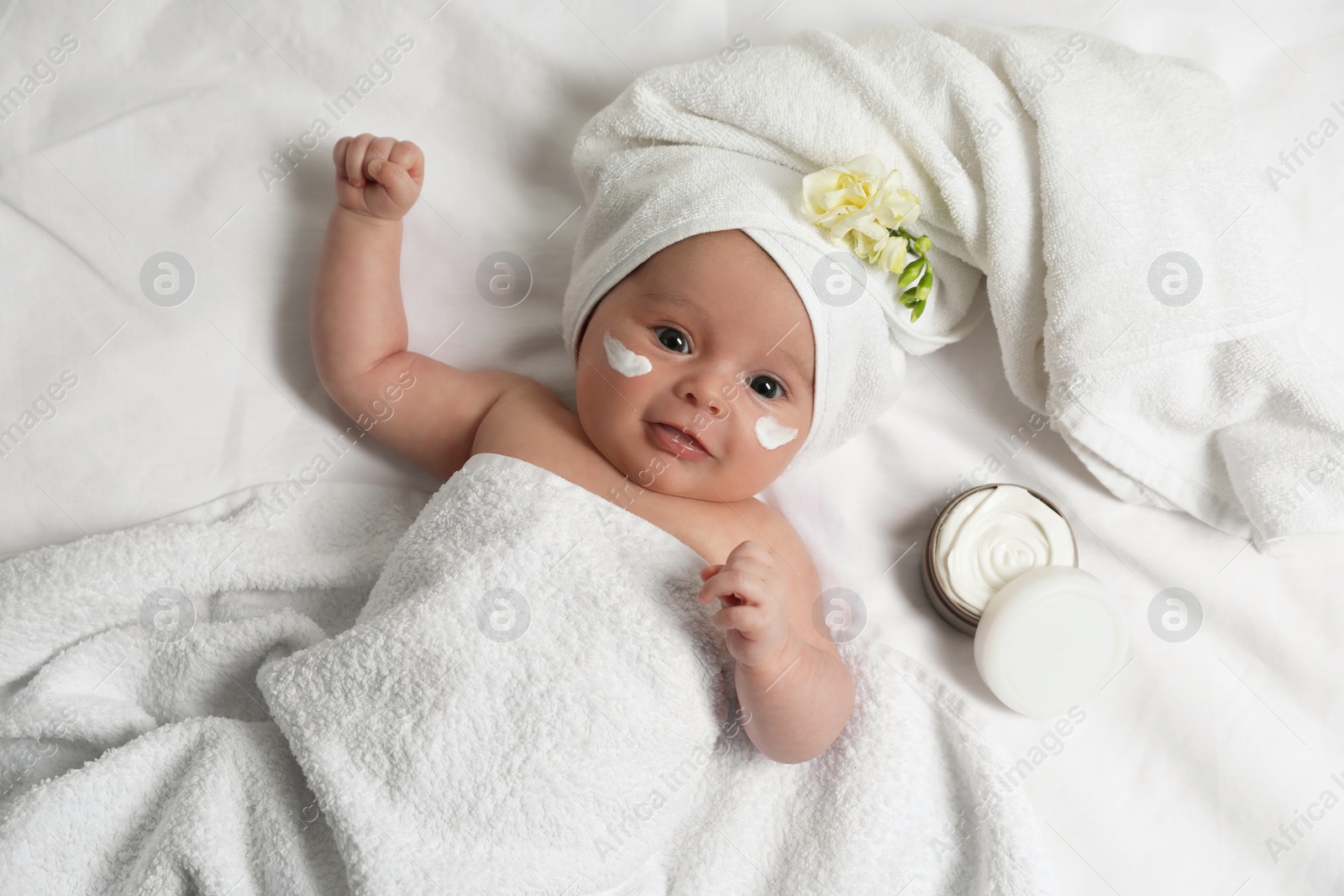 Photo of Cute little baby with cream on face, top view