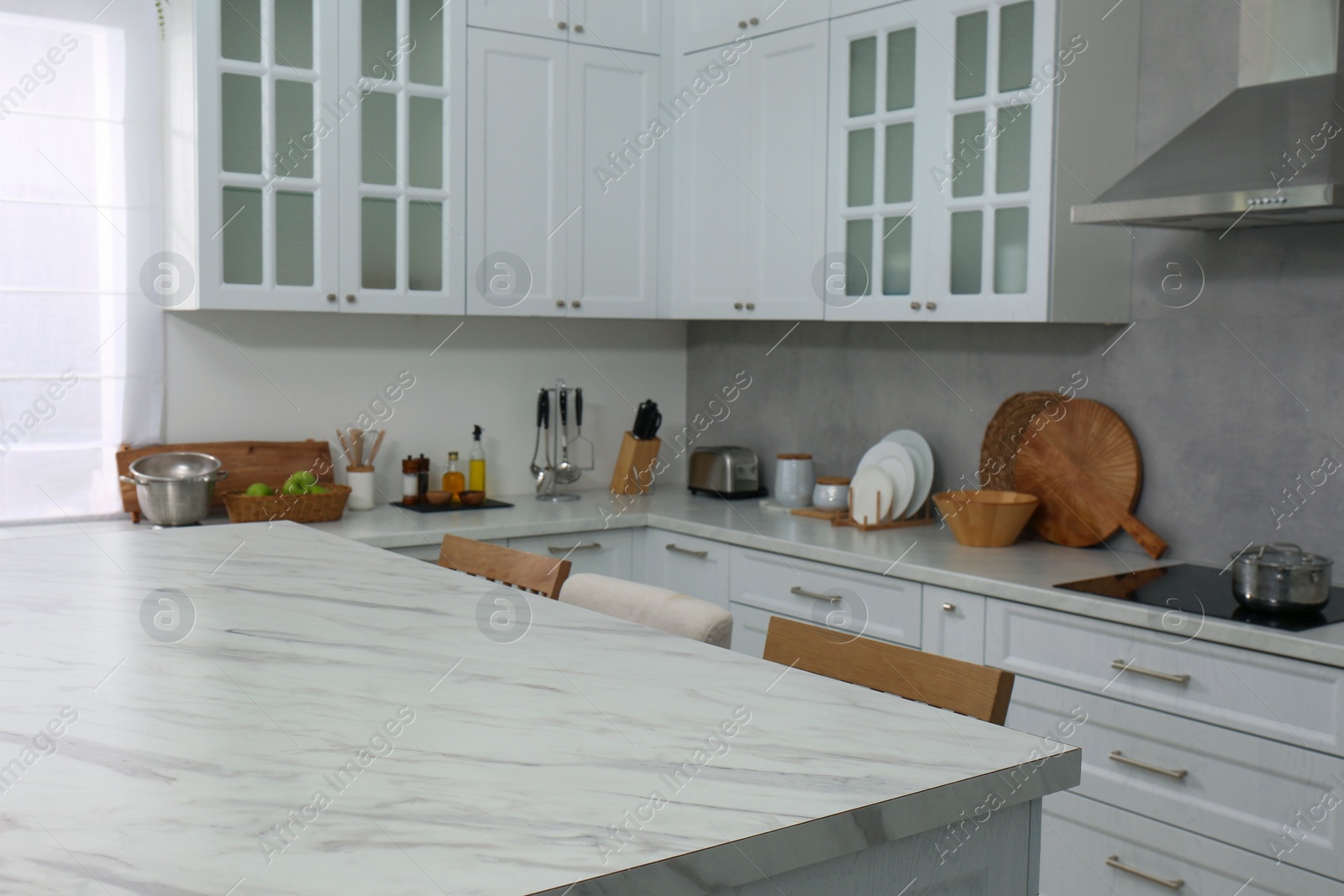 Photo of Stylish white marble table in kitchen. Interior design