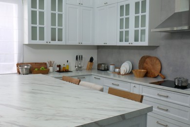 Photo of Stylish white marble table in kitchen. Interior design