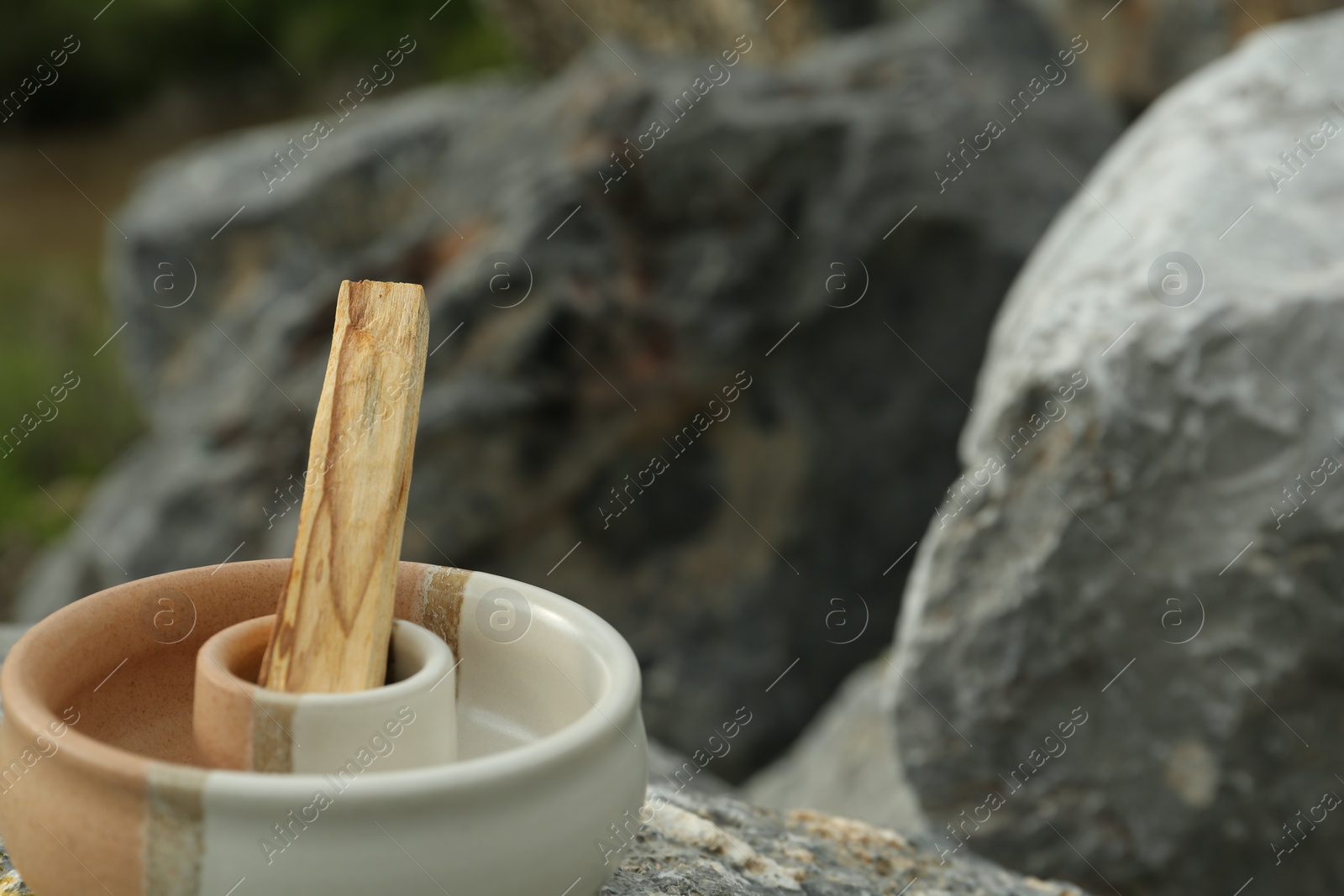 Photo of Palo santo stick on stone surface, closeup. Space for text