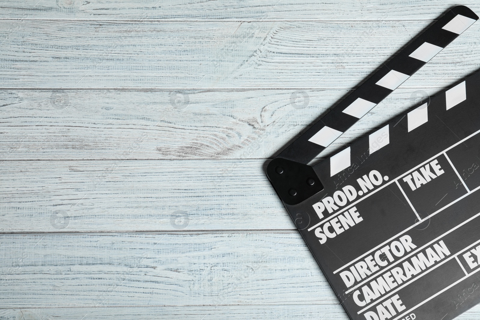 Photo of Clapperboard on white wooden table, top view with space for text. Cinema production