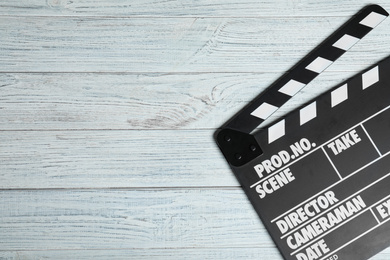 Clapperboard on white wooden table, top view with space for text. Cinema production