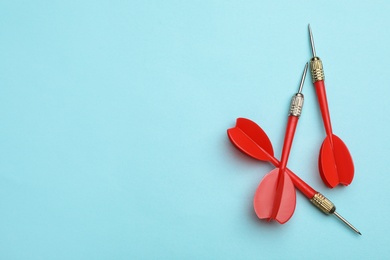 Photo of Red dart arrows on blue background, flat lay with space for text