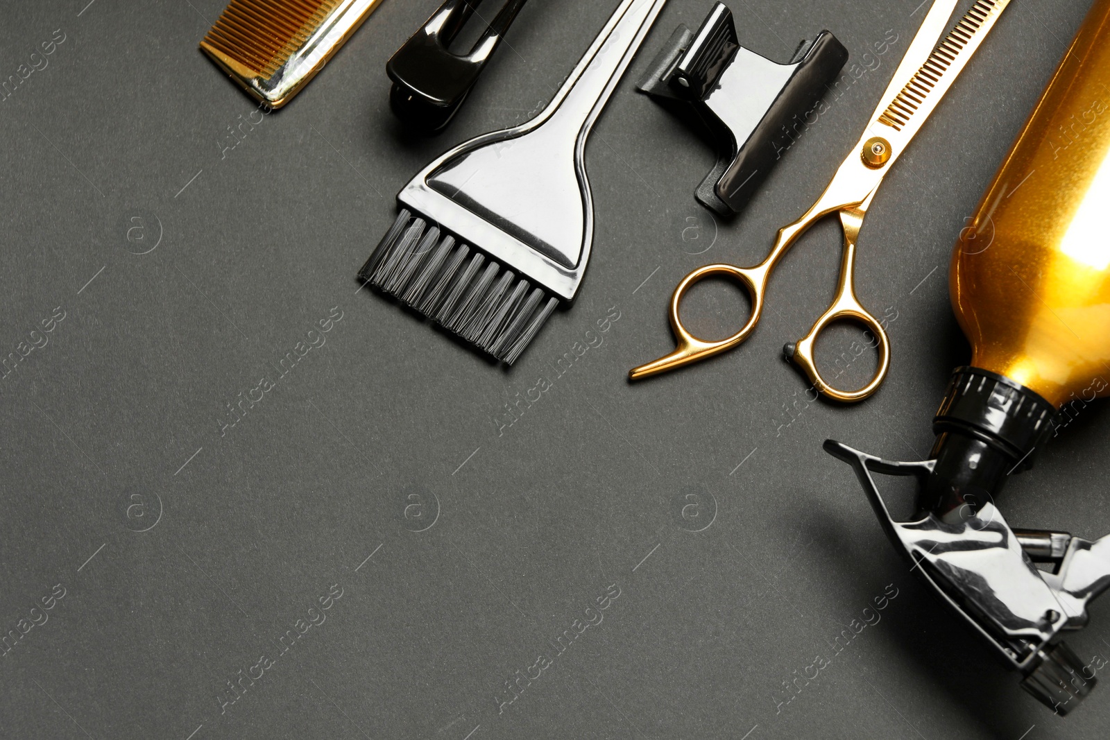 Photo of Hairdressing tools on dark table, flat lay. Space for text