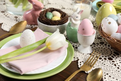 Photo of Festive table setting with painted eggs, closeup. Easter celebration