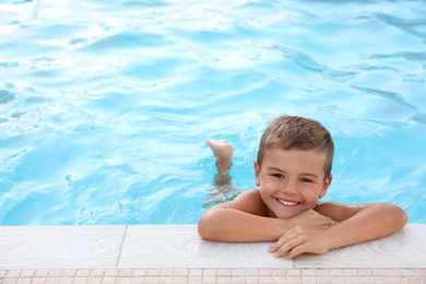 Photo of Cute little boy in outdoor swimming pool