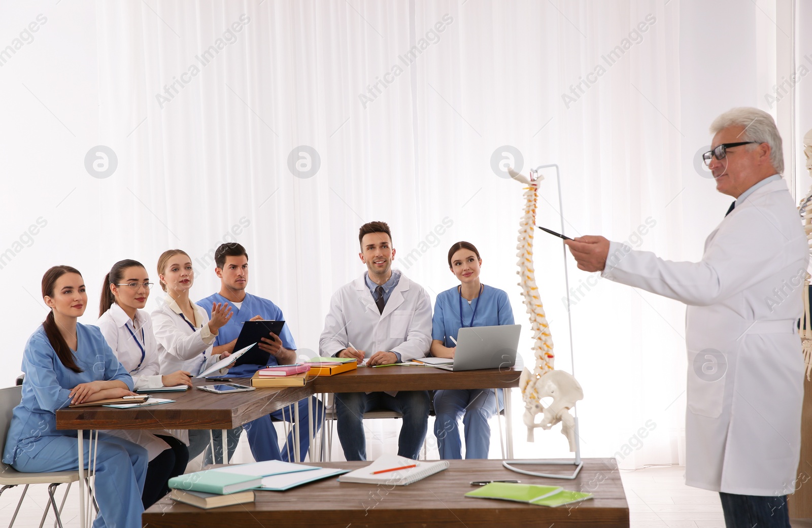 Photo of Medical students and professor studying human spine structure in classroom