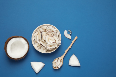 Flat lay composition with tasty coconut chips on blue background