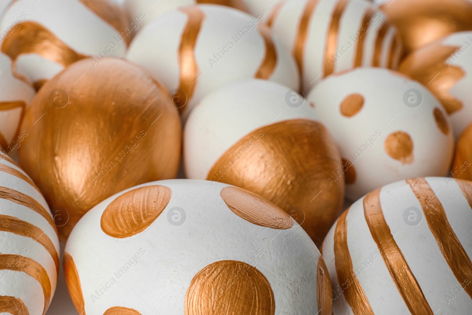 Photo of Traditional Easter eggs decorated with golden paint, closeup