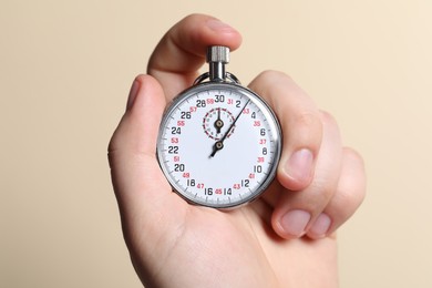 Photo of Man holding vintage timer on beige background, closeup