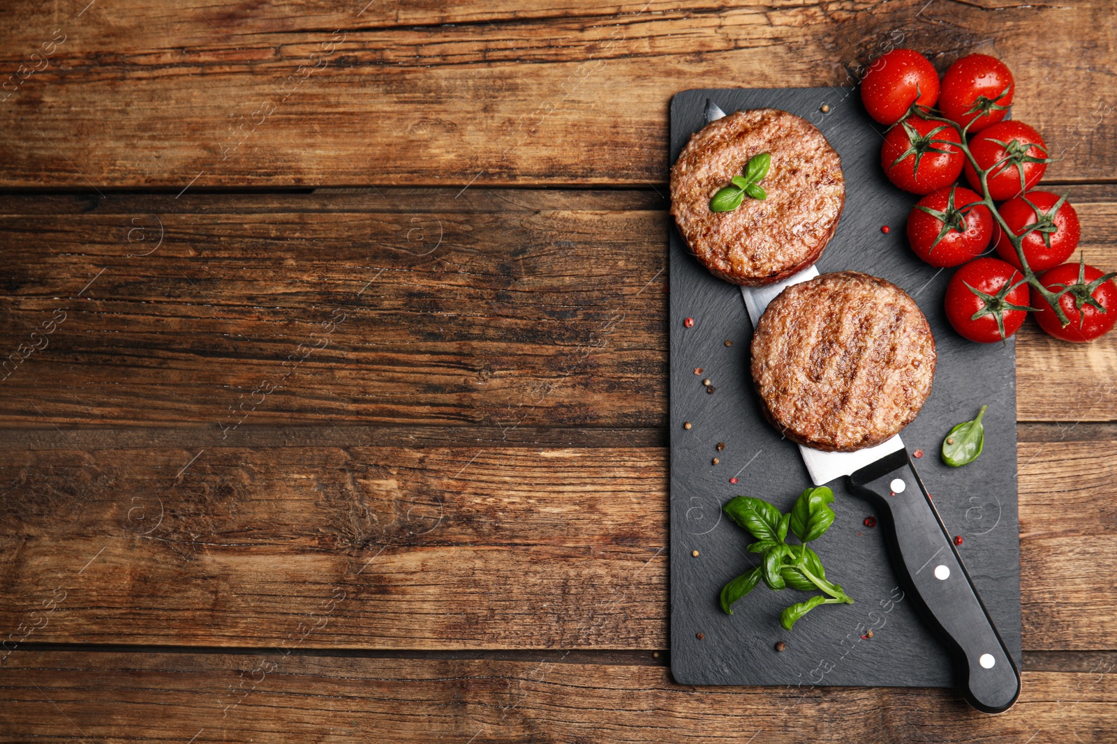 Photo of Tasty grilled hamburger patties served on wooden table, flat lay. Space for text