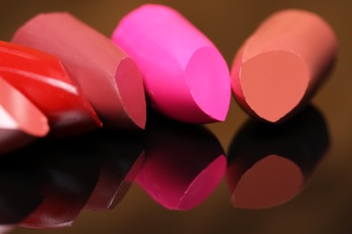 Photo of Many different bright lipsticks on mirror, closeup