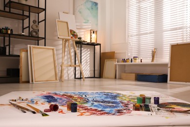 Photo of Wooden easel and abstract picture in art studio