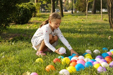 Photo of Little girl with water bombs in park